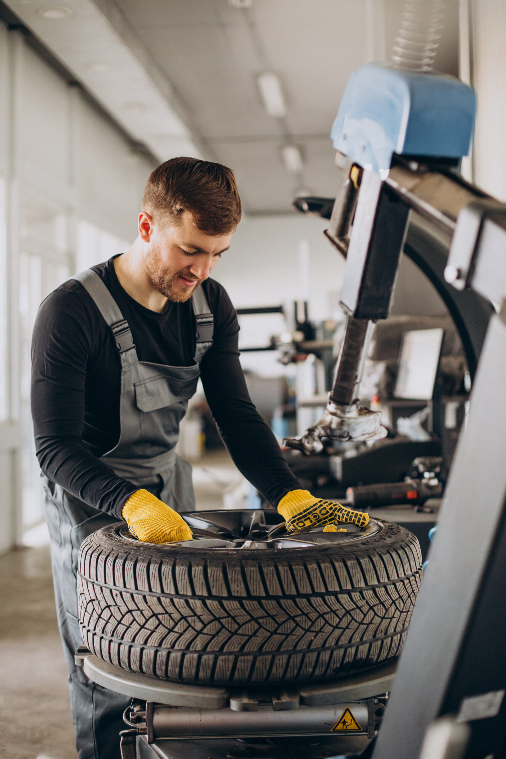 Car mechanic changing wheels in car